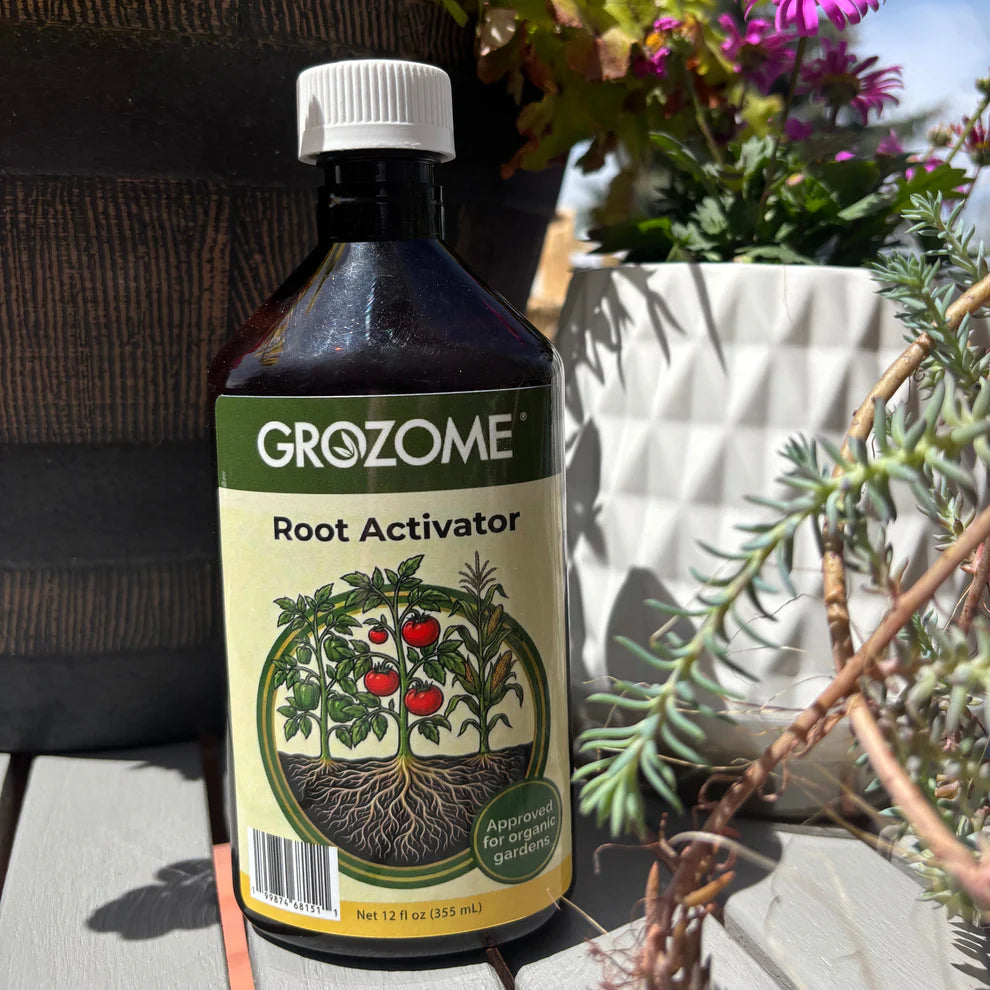 Bottle of GroZome Root Activator with plants in the background